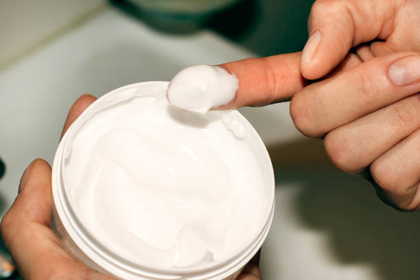 istock Skin care: cream jar in girls hand 917980282
