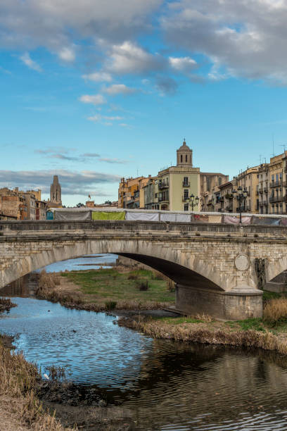 istock Girona cityscape with stone bridge landmark over Onyar river on a cloudy and sunny day 917991476