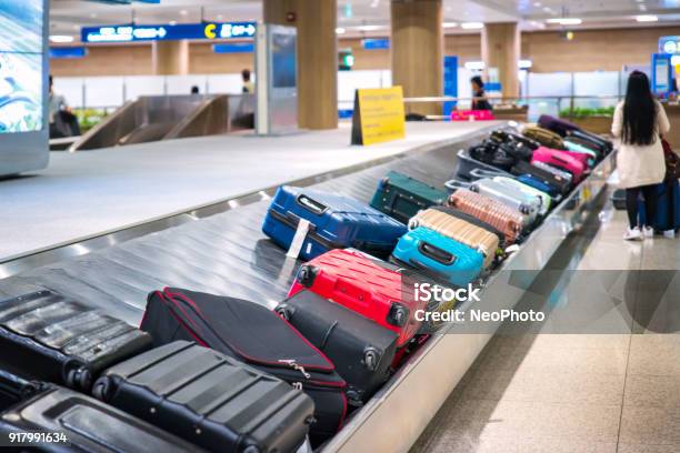 Traveler Waiting For A Travel Bag On The Belt In Airport Stock Photo - Download Image Now