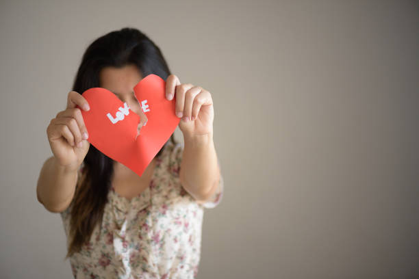 istock Woman holding red broken heart with love text. valentines day concept. 917998400