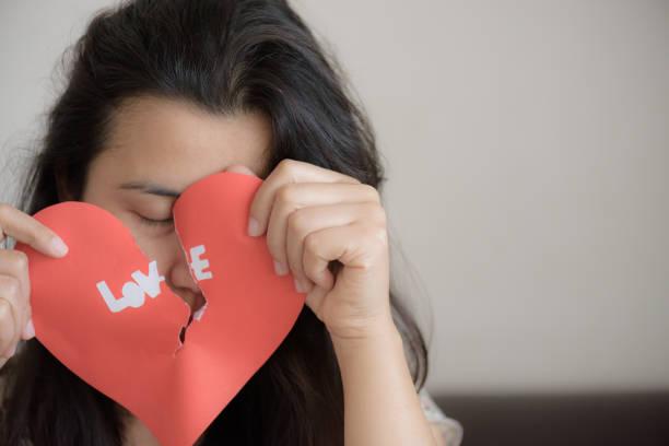 istock Woman holding red broken heart with love text. valentines day concept. 917998440