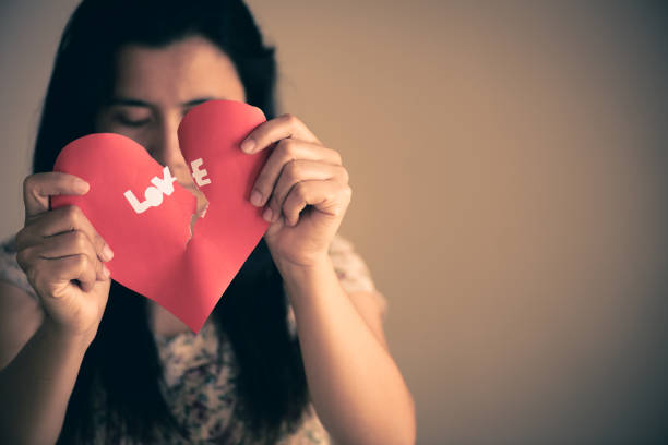 istock Woman holding red broken heart with love text. valentines day concept. 917998486