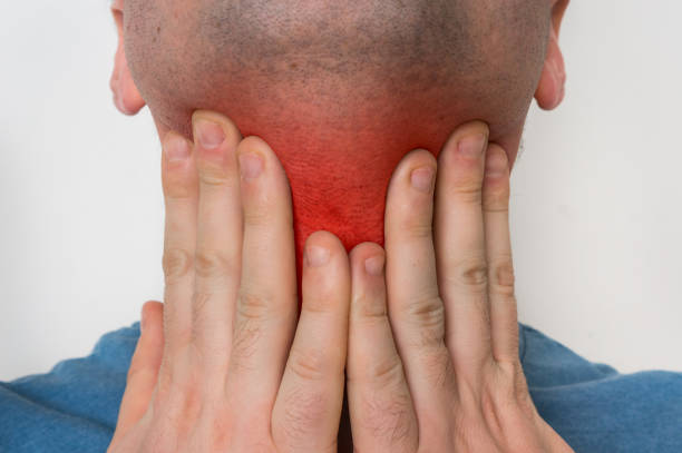 istock Man with throat sore is holding his aching throat 918004322