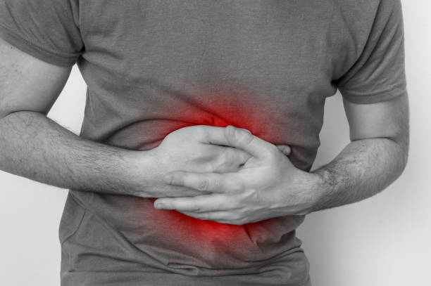 istock Man with stomach pain is holding his aching belly 918006356