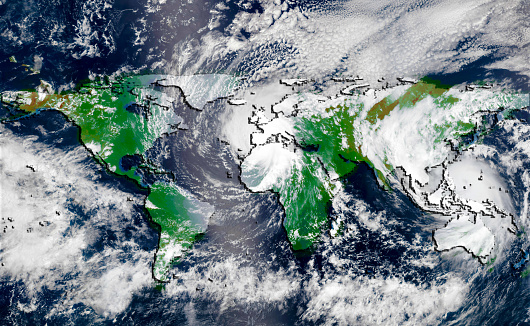 Hurricane over the green world map silhouette, elements of this image furnished by NASA. Concept of global climate changing.