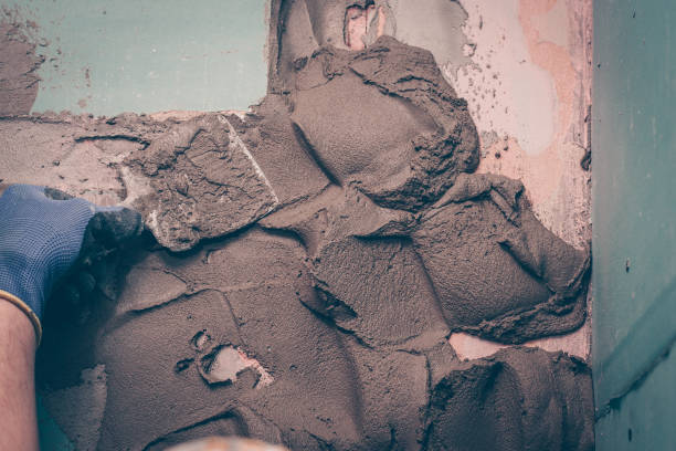 istock The worker applies the plaster to the wall for leveling, based on the tile work 918007636