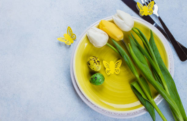 istock Easter table setting with spring tulips, quail eggs and cutlery. Spring Holidays Stone Blue background. Top view, flat lay, copy space 918008388