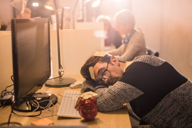 istock Overworked freelancer sleeping on the desk in the office. 918019296
