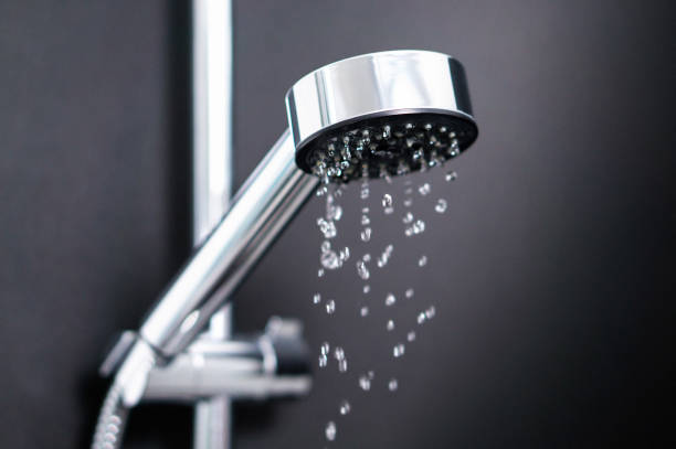 Turning off or on running water in shower. Last or first drops splash from faucet. Water consumption, bill, saving, shortage and ecology concept. stock photo