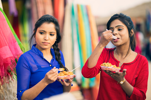 Women eating snack at street market