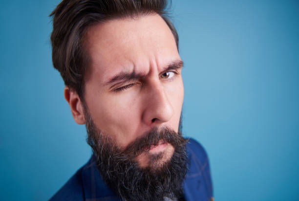 Handsome man with beard winking Handsome man with beard winking blinking stock pictures, royalty-free photos & images