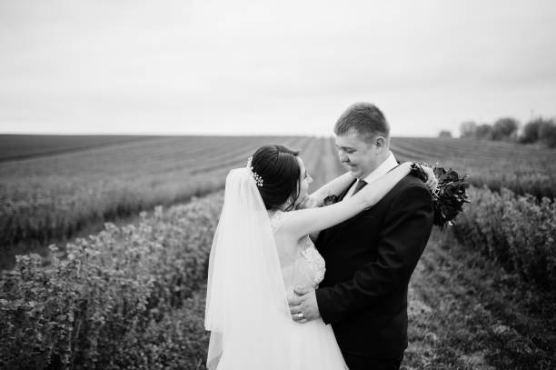 istock Attractive young wedding couple posing on the blackcurrant field on their wedding day. 918024242