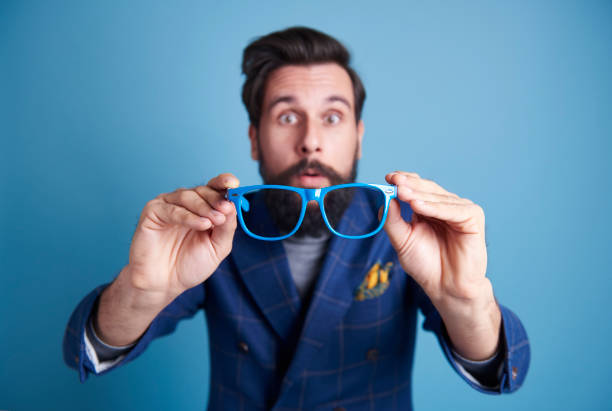 istock Surprised man holding glasses at studio shot 918031760