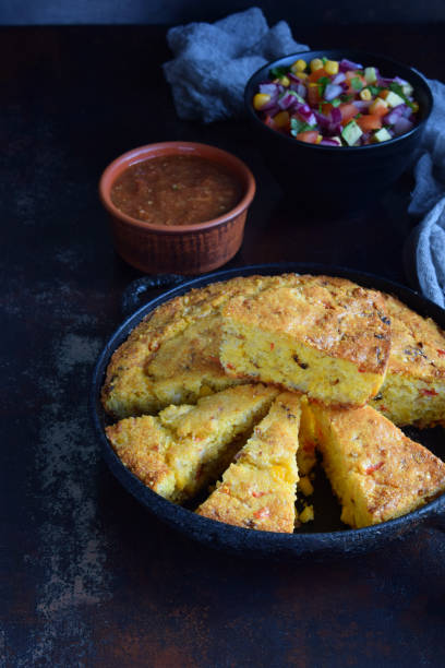 istock Cornbread and other mexican food - salsa with tomato, red onion, lime, cilantro, corn and hot pepper sauce. Copy space. 918036084