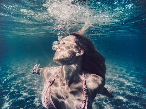 istock Beautiful woman swimming underwater 918038542