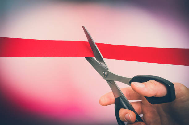 istock Hand with scissors cutting red ribbon - opening ceremony 918039514