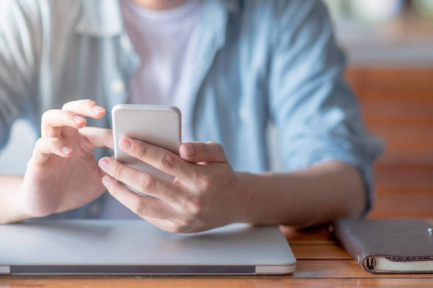 istock male hand texting message on social media application on smartphone in workspace 918042384