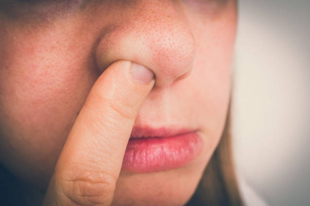 kobieta zbiera nos z palcem w środku - picking nose zdjęcia i obrazy z banku zdjęć