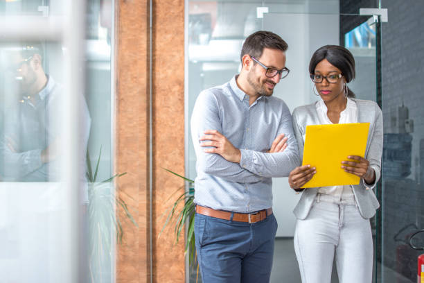 istock Two business people discussing about document in office hall. 918046382