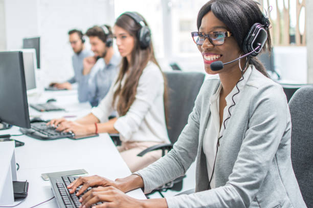 souriante jeune femme avec casque travaillant dans le centre d’appels. - receptionist customer service customer service representative photos et images de collection