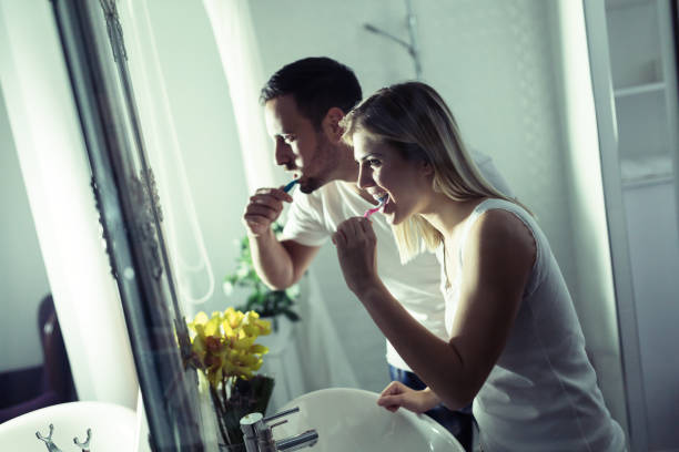 istock Happy young couple brushing teeth in bathroom 918046490