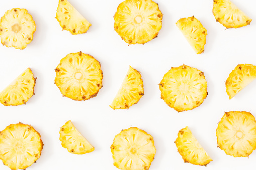 Pineapples on white background. Pattern made of sliced pineapples. Flat lay, top view, copy space