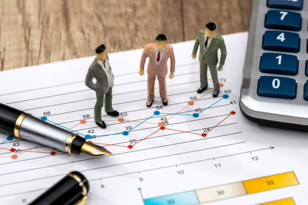 istock mini people with a graphic and a calculator 918050332