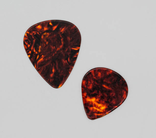 istock Two different sizes of brown plastic guitar plectrum isolated on white background. Guitar Picks 918056748