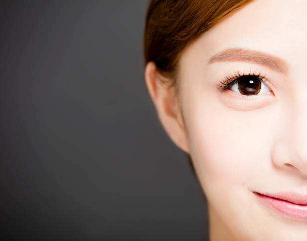 istock closeup half smiling woman face with Beautiful eyes 918060972