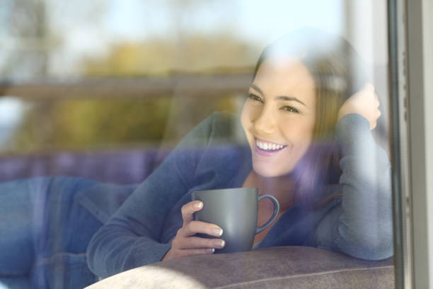 istock Happy woman resting looking through a window 918064944