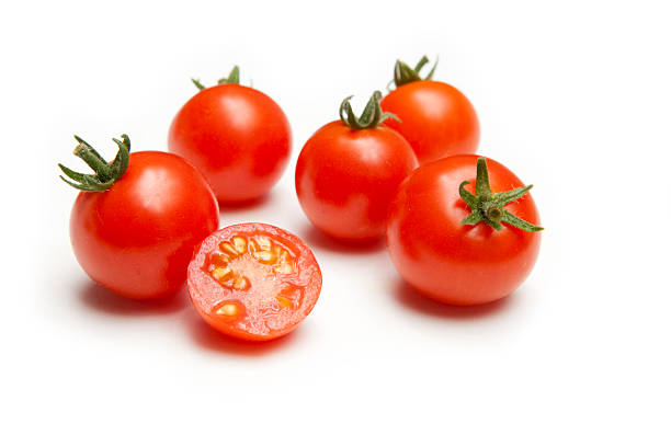 vine tomates cereza maduros con rodajas media - tomatoes on vine fotografías e imágenes de stock