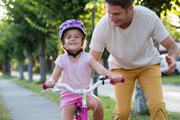 Mid adult man helping daughter