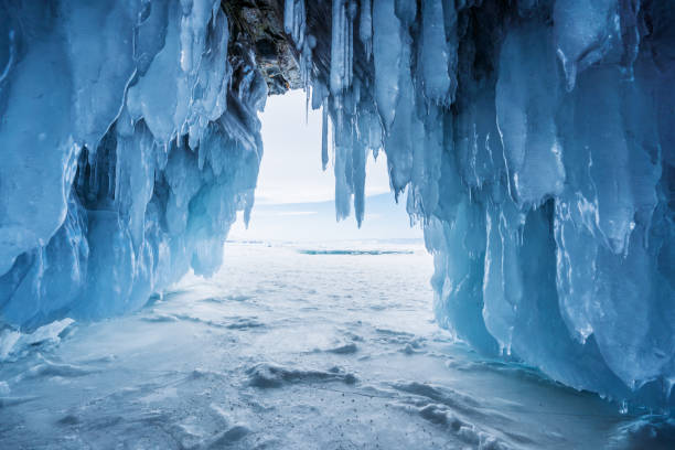 冬の風景、イルクーツク、ロシアのバイカル湖で出口から明るい日差しに冷凍氷の洞窟 - アイスクライミング ストックフォトと画像