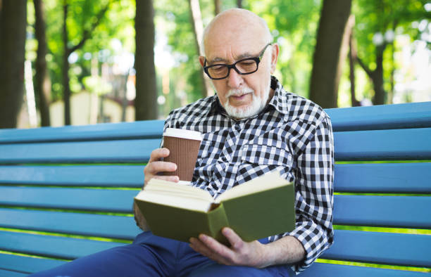 istock Elderly man in casual reading outdoors 918078590