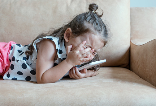 Little girl crying with digital tablet