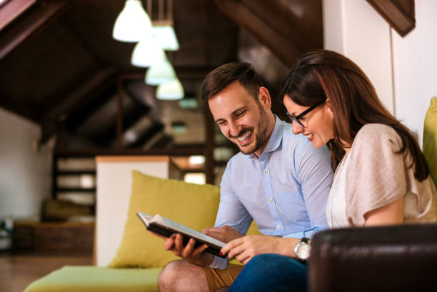 istock Romantic couple laughing together and reading a book. 918091214
