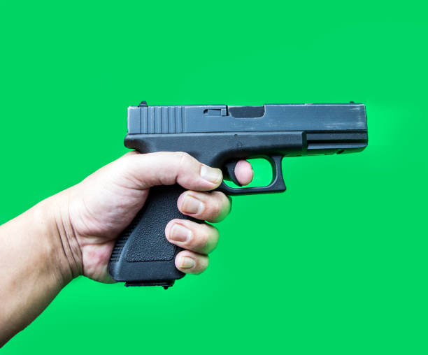 istock hand hold gun on green screen 918095860