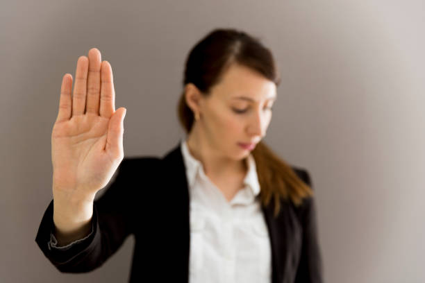 Woman in business suit showing her palm, body language, say NO at work, self-awareness stock photo