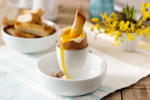istock Breakfast from soft-boiled egg, bread toast, coffee with cream and fresh newspaper. 918099506