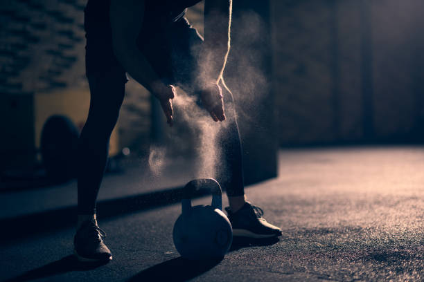 Cross Training Unrecognizable male athlete applying sports chalk before performing kettlebell exercise in the gym. crossfit chalk weightlifting weight training stock pictures, royalty-free photos & images