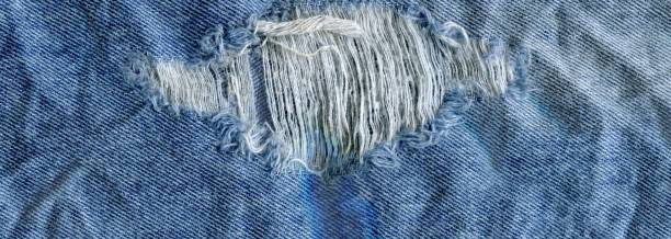 istock Blue denim jean texture background. Jeans torn fabric texture 918107410