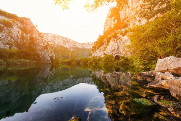 Photo of Beautiful landscape, canyon of the Cetina river with reflection in crystal clear water at sunset, Omis, Croatia