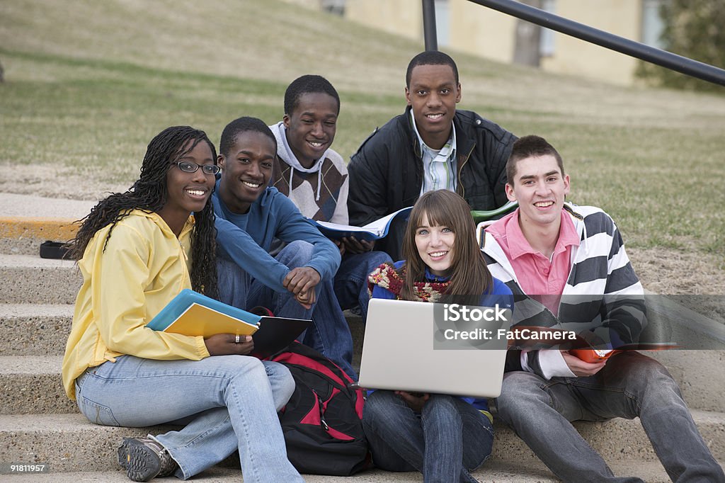 Students A group of college students sitting on the stairs on a university campus and studying with a laptop 18-19 Years Stock Photo