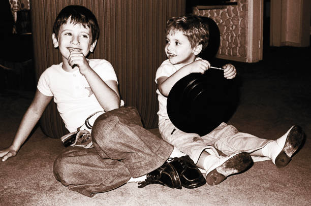Vintage happy kids having fun Vintage black and white image of a cute children sitting on floor and  playing at home 20th century style photos stock pictures, royalty-free photos & images