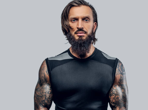 Sporty bearded male with tattooed body. Sporty bearded male with tattooed body isolated on grey background. cross shoulder tattoos stock pictures, royalty-free photos & images