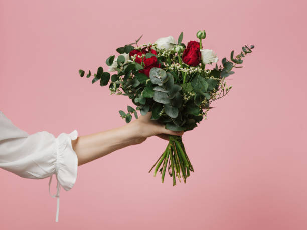 ピンクの背景の花バラの美しい花束を保持している女性の写真 - rose pink flower single flower ストックフォトと画像