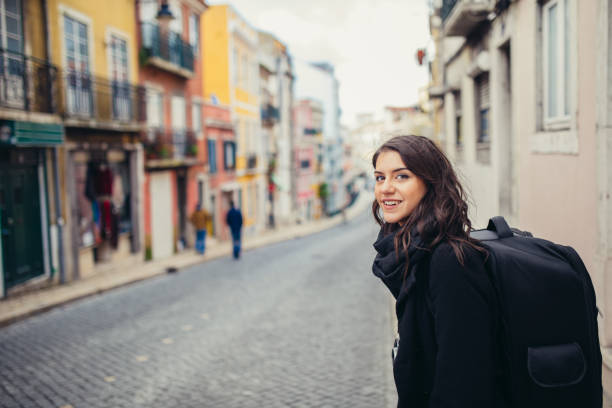 Enthusiastic traveler woman walking streets of european capital.Tourist in Lisbon,Portugal. stock photo