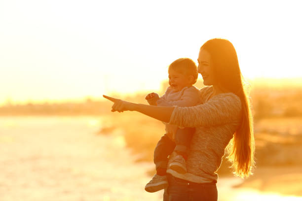 istock Happy mother and kid looking away at sunset 918128584