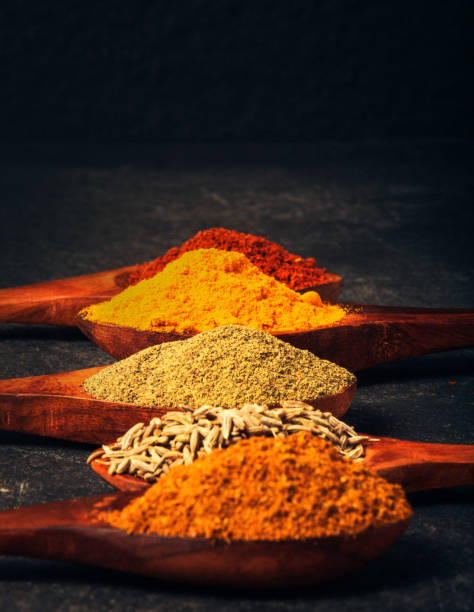 крупным планом выстрел различных специй в деревянных ложках на столе - indian culture spice cooking herb стоковые фото и изображения