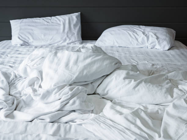 istock messy white bedding sheets and pillow in bedroom background ,Unmade messy bed after comfort sleep concept 918135450